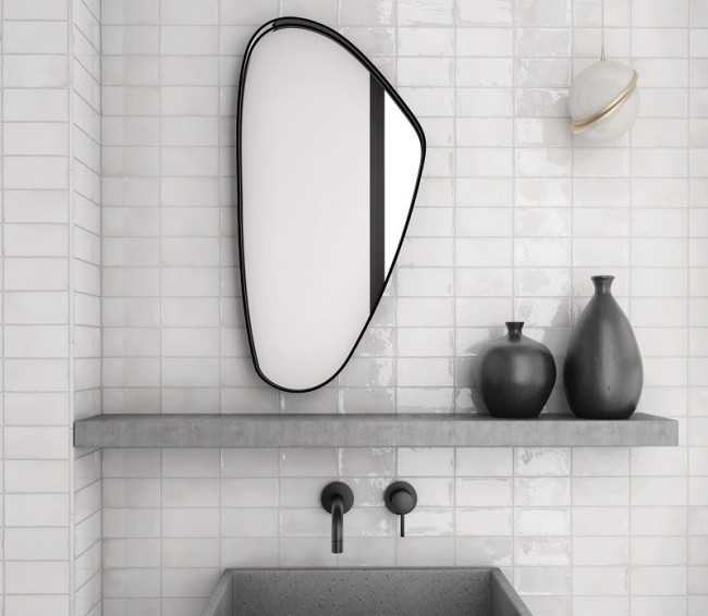 Bathroom with tiled wall, sink, and mirror.